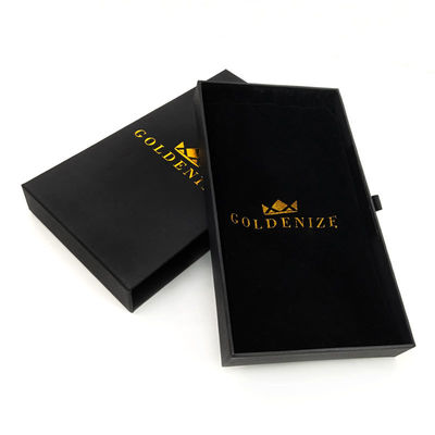 Un elegante cajón negro rígido con logotipo personalizado de papel de oro y revestimiento de terciopelo suave.