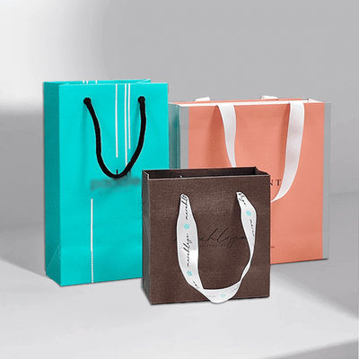Bolsas de regalo personalizadas de alta gama en mano Tienda de ropa Bolsas de papel Kraft artesanal personalizadas Embalaje de regalos