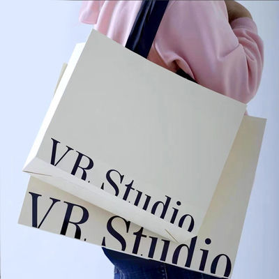 Bolsas de ropa personalizadas Embalaje de lujo de cartón de marfil Kraft papel de bajo precio Bolsa de regalo de compras Logotipo personalizado