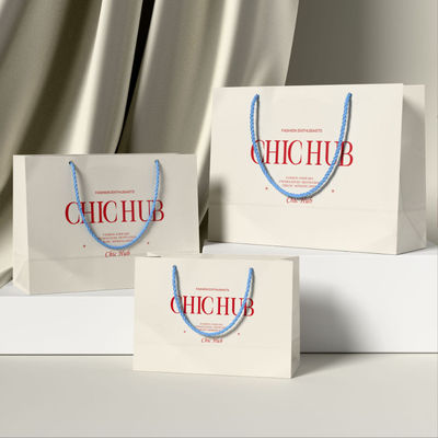 Bolsas de ropa personalizadas Embalaje de lujo de cartón de marfil Kraft papel de bajo precio Bolsa de regalo de compras Logotipo personalizado