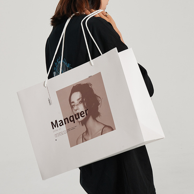 Bolsas de compras de lujo premium de papel blanco con impresión personalizada y diseño de asa de cinta